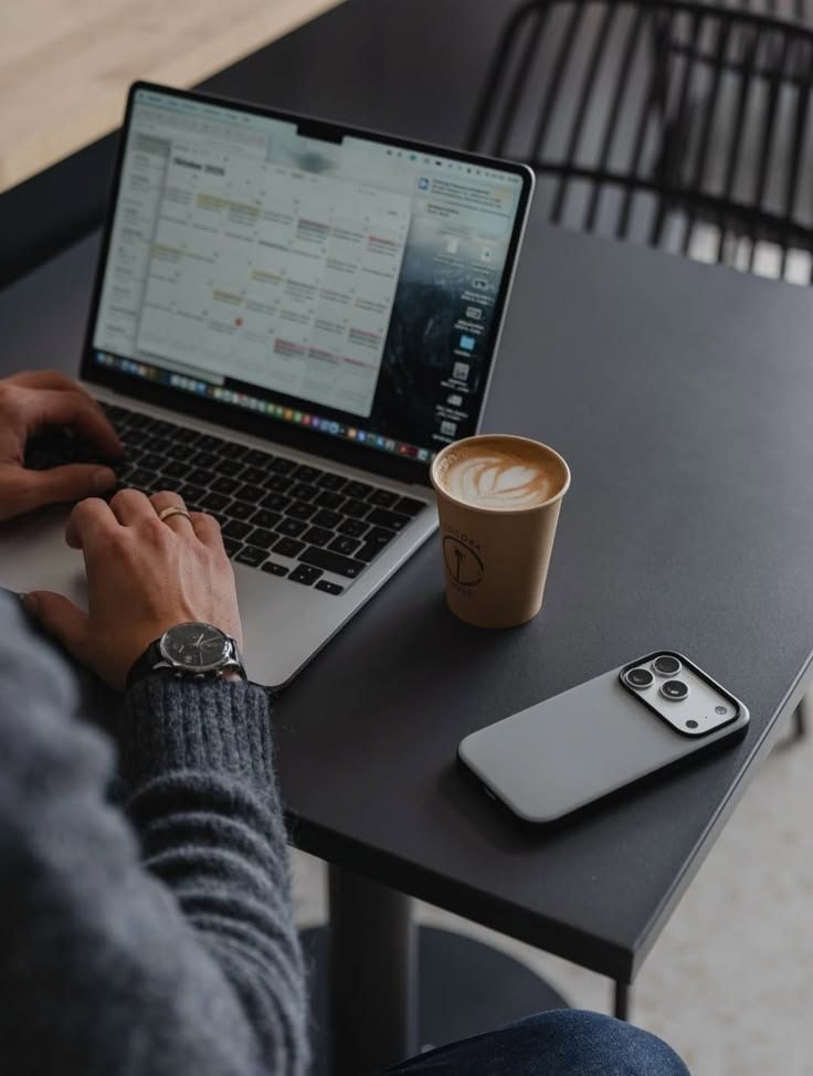 A creative working on their own laptop with a coffee